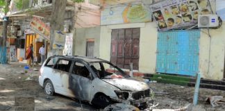 Somalis walk past the wreckage of a vehicle and a motorcycle destroyed at the scene of a suicide bomb blast at the Hamar Weyne district of Mogadishu, Somalia January 16, 2024. REUTERS/Feisal Omar Acquire Licensing Rights