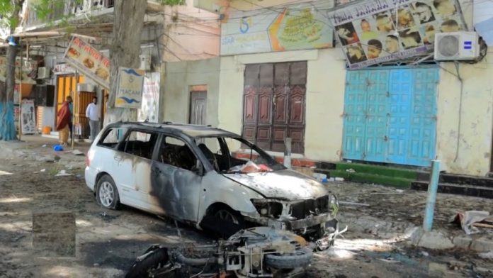 Somalis walk past the wreckage of a vehicle and a motorcycle destroyed at the scene of a suicide bomb blast at the Hamar Weyne district of Mogadishu, Somalia January 16, 2024. REUTERS/Feisal Omar Acquire Licensing Rights